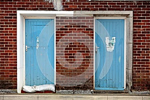 Two Old Blue Doors Surround by Brickwork