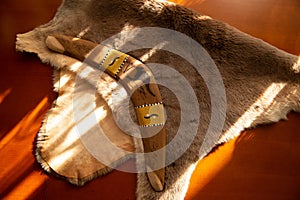 Two old boomerangs laying on the kangaroo skin, fur with wooden glossy table in the background. Souvenirs from Australia on