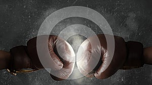 Two old brown boxing gloves hit together photo