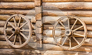 Two old cartwheel on a wooden wall