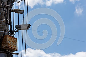two old cctv security surveillance cameras on street light pole on blue sky background