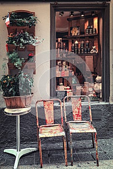 Two old chairs in front of the window of a shop in the old city of Nice