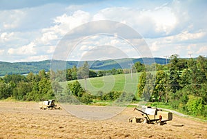 Two old harvesters working on a grain field