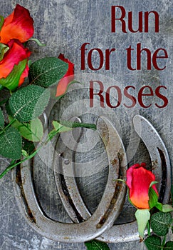 Two old horse shoes paired with silk red roses on a scratched up steel background