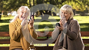 Two old ladies doing make up, sitting on bench in park, anti-age cosmetics
