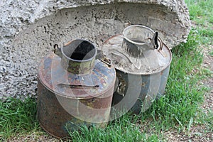 Two old metal cans on grassy soil