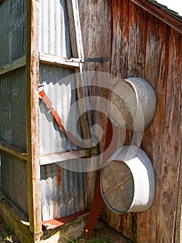 Two old pans or tubs hanging on exterior wall of rustic building