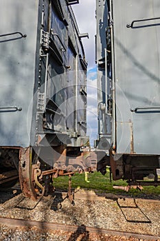 Two old rusted antique railroad train cars coupled together.