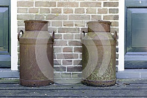 Two old rusted churns