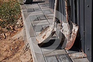 Two old rusty shovels in cement.