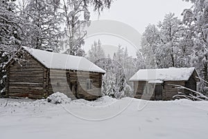 Two old timbered houses in a snowy forest