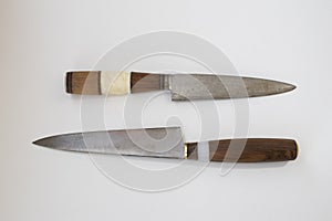 Two Old vintage homemade kitchen or household knife with a wooden handle and a blade from a saw blade  on a white