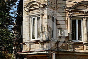 Two old white windows on the brown concrete wall