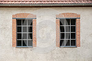 Two windows on a grey plaster wall