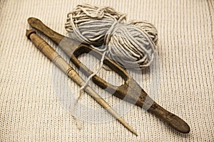 Two old wooden spindle with a ball of wool thread for the manufacture of woolen threads on a tissue background