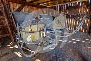 Two old wooden vintage sleighs or sleds in an old restored barn