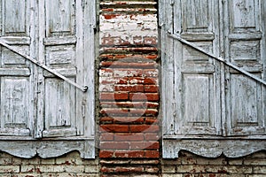 Two old wooden white windows were destroyed by time. Brick wall