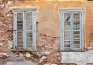 Two old wooden windows on grunge weathered wall.