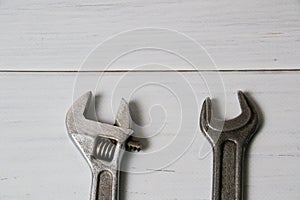 Two old wrenches, adjustable spanner and spanners, on light wooden background with copy space