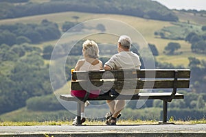 Two older people sitting on a bench photo