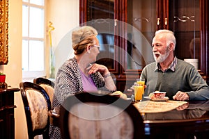 Two older people talking and enjoying in delicious foods