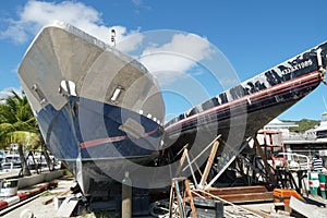 Two older yachts stored on workshops near marina are ready for repair in harbor of Philipsburg in Caribbean Island.