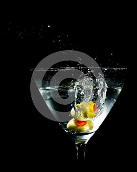 Two Olives Splashing into Martini Glass