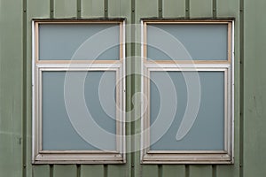 Two opaque windows on green wall