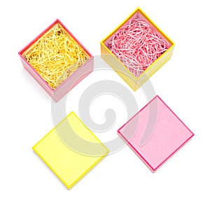 Two open gift boxes with decorative shavings on white
