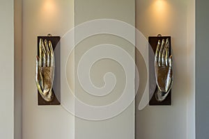Two open palm hands of buddha - decorative modern art sculpture elements of interior on the wall