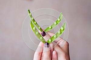 Two open pea pods in woman`s hand