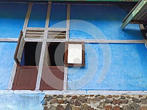 Two open windows against blue wall.