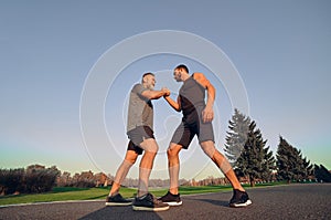 The two opponents holding hands in the park.