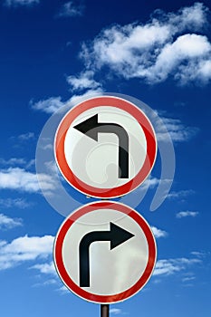 Two opposite road signs against blue sky