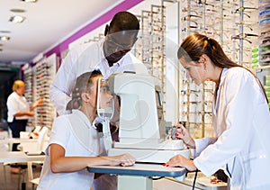 Two opticians testing teenager eyesight