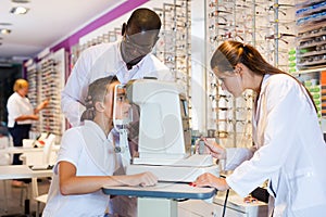 Two opticians testing teenager eyesight