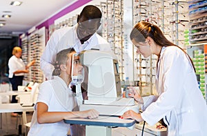 Two opticians testing teenager eyesight