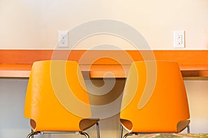 two orange chairs at an orange desk
