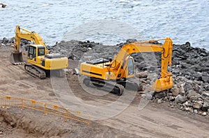Two orange excavators