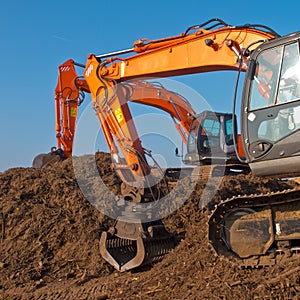 Two orange excavators