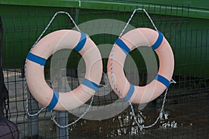 Two orange lifebuoys on hanging on a wooden wall of a boat station photo