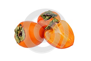 Two orange persimmons fruits or diospyros and one cut off half of persimmon with green leaves on white background isolated closeup