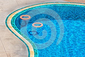 Two orange ring lifebuoys in swimming pool