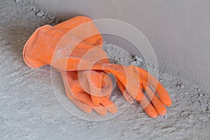 Two orange rubber gloves on concrete flloor