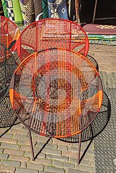 Two orange tinted chairs with mesh structure