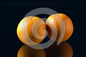 Two oranges on black background