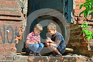 Two orphans were left homeless and sitting near the ruins of the building as a result of a military conflict, a fire and an earthq