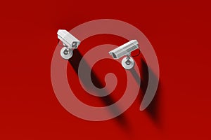 Two outdoor surveillance cameras on a red wall, security system