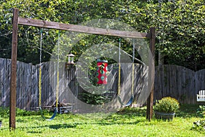 Two outdoor swings along with two bird feeders