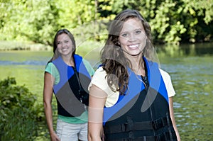 Two outdoorsy females with life jackets